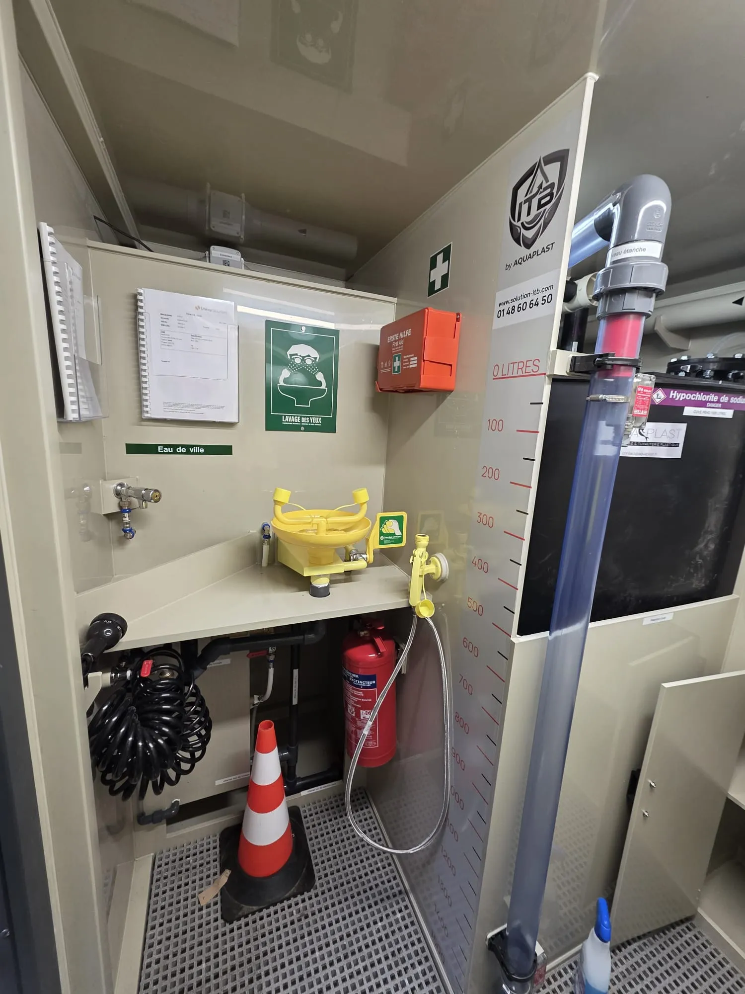 Intérieur d’une station ITB&nbsp;: parois et tablette du compartiment technique, poste de lavage oculaire, extincteur et jauge de niveau de la cuve