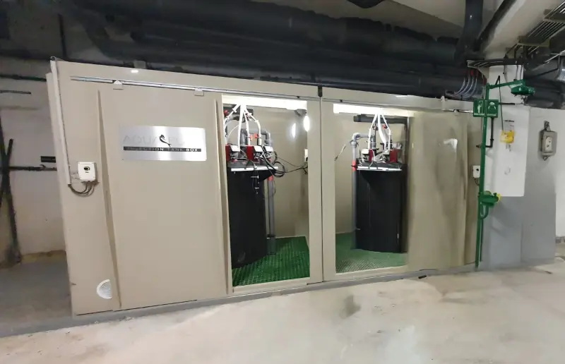 Deux unités ITB Indoor installées dans le local technique du centre aquatique de Vincennes, portes ouvertes sur les cuves et les pompes doseuses